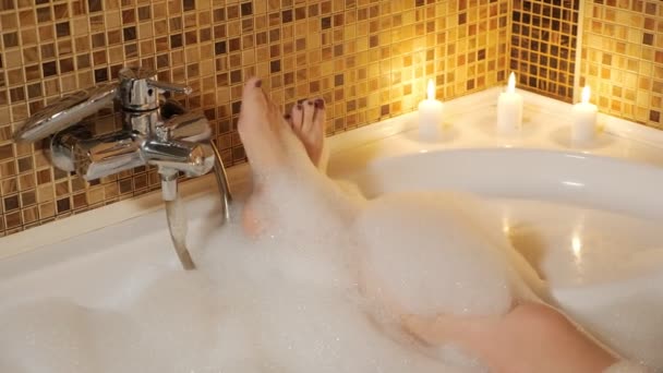 Pés de mulher em um banho de espuma. Relaxamento doméstico
 - Filmagem, Vídeo