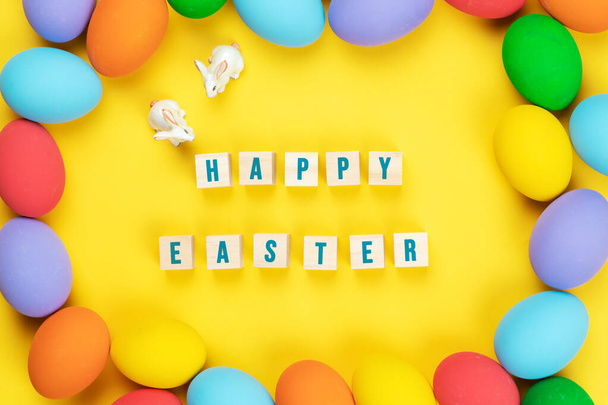 Ημέρα του Πάσχα μικρό λαγουδάκι κουνέλι με διακοσμημένα αυγά σε κίτρινο φόντο - Φωτογραφία, εικόνα