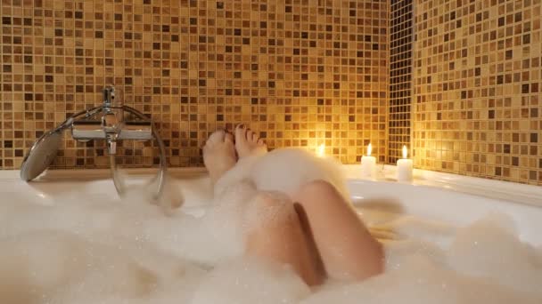 Női lábak egy habfürdőben. Otthoni kikapcsolódás - Felvétel, videó