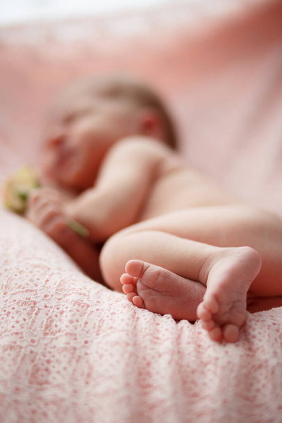 Nouveau-né avec de petits pieds dormant sur une serviette
 - Photo, image