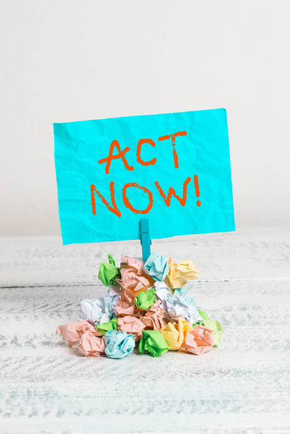 Conceptual hand writing showing Act Now. Business photo showcasing fulfil the function or serve the purpose of Take action Do something Reminder pile colored crumpled paper clothespin wooden space. - Photo, Image