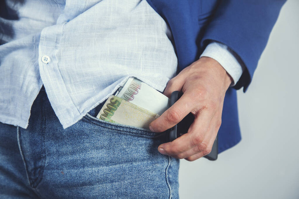 fiatal üzletember kézpénz a zsebében - Fotó, kép