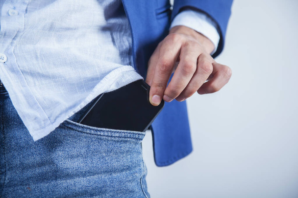 бізнесмен ручний телефон на кишені на сірому фоні
 - Фото, зображення