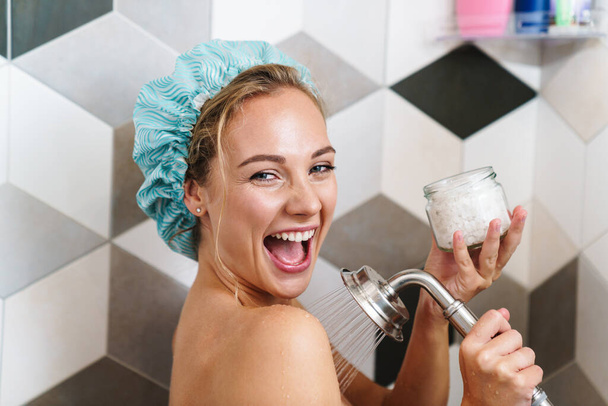 Image of young beautiful happy naked woman smiling while taking shower in bathroom at home - Фото, зображення