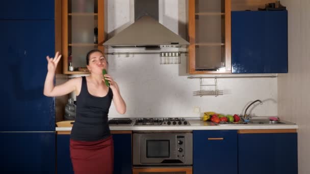 happy woman sings using cucumber as microphone and grimaces - Footage, Video