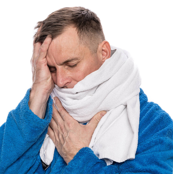 Terveydenhuolto, kipu, stressi. Sairas mies kylpytakissa käärittynä pyyhkeeseen valkoisella taustalla
 - Valokuva, kuva