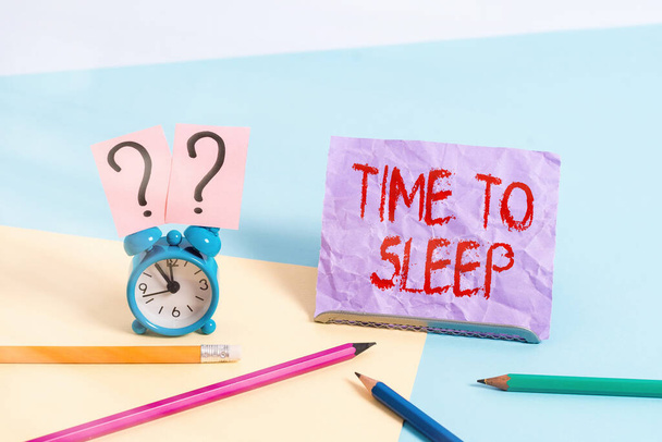 Text sign showing Time To Sleep. Conceptual photo a natural period of slumber or to be in state of inactivity Mini size alarm clock beside stationary placed tilted on pastel backdrop. - Photo, Image