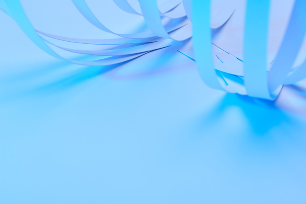 close up vista de listras de papel curvo no fundo azul néon
 - Foto, Imagem