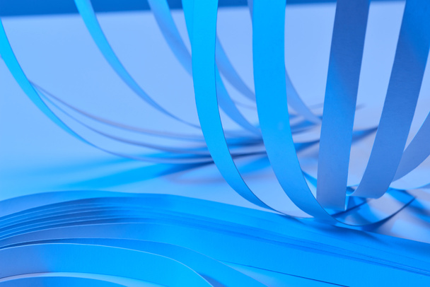 close up view of paper stripes on neon blue background - Photo, Image
