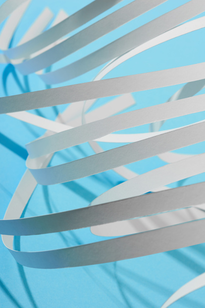 close up view of white curved paper stripes on blue background - 写真・画像