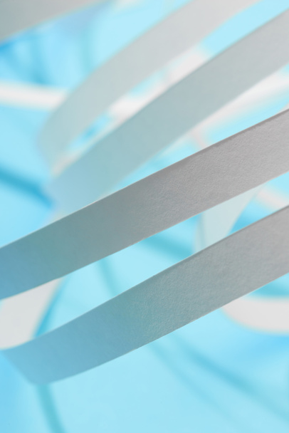 close up view of white paper stripes on blue background - Foto, Imagem