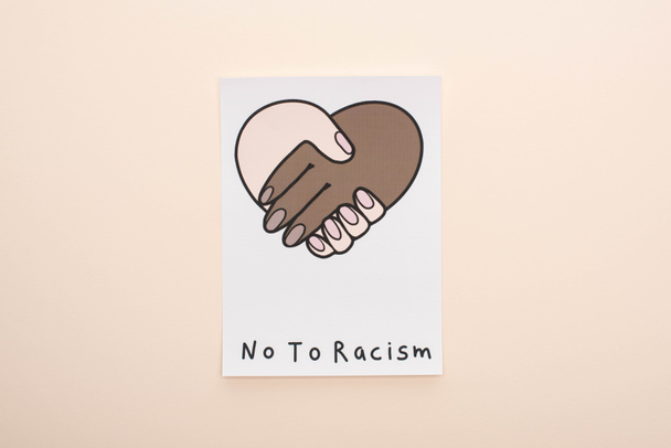 vista superior de la imagen con apretón de manos multiétnico y no a las letras de racismo sobre fondo beige
 - Foto, imagen