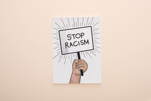 top view of picture with drawn hand and stop racism placard on beige background - Photo, Image