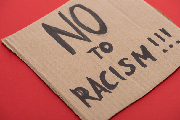 karton z napisem "nie" dla rasizmu na czerwonym tle - Zdjęcie, obraz