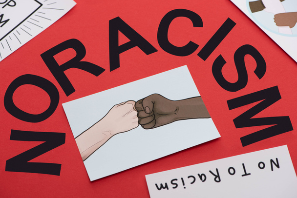 fekete nincs rasszizmus betűk és kép rajzolt többnemzetiségű kéz csinál ökölpacsi piros háttér - Fotó, kép
