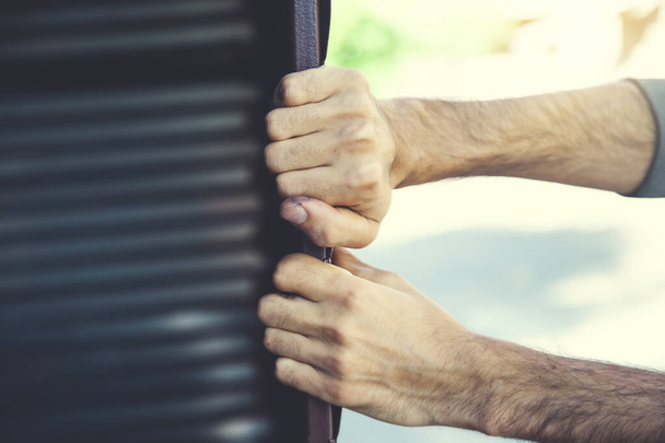 man hand holding garage door in nature - Photo, Image