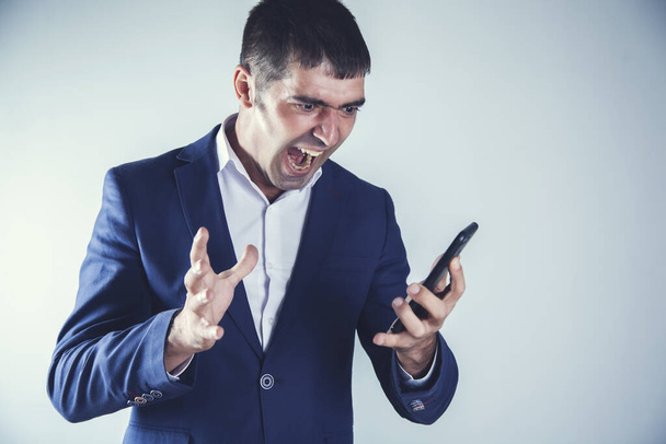 wściekły człowiek krzyczy i trzyma telefon  - Zdjęcie, obraz