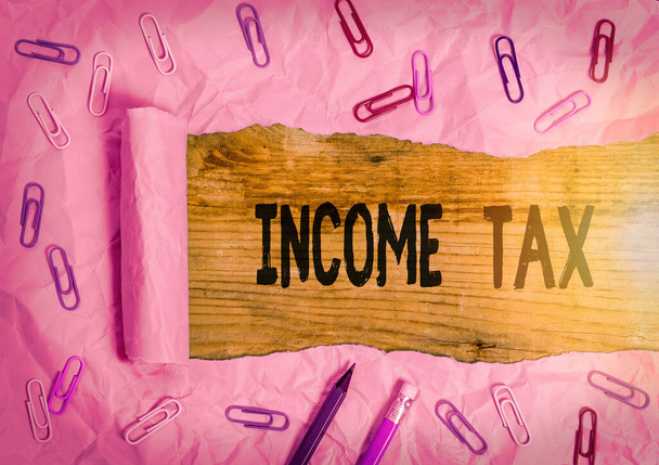 所得税を示すメモを書く。収入と未収入の両方に課税された年間費用を紹介するビジネス写真. - 写真・画像