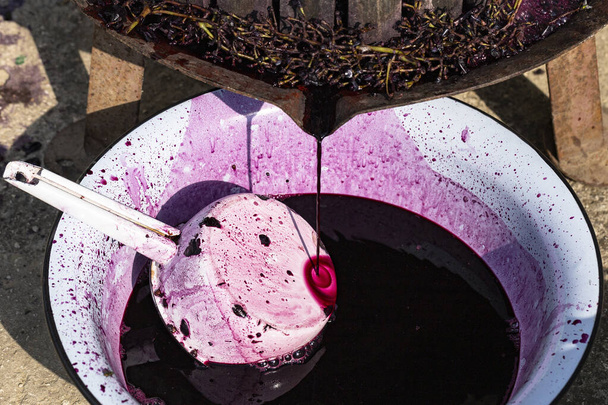 Wine making. Technology of wine production in Moldova. The ancient folk tradition of grape processing. The squeezer is used to press the wine. - Photo, Image