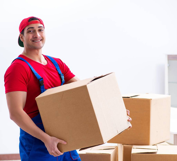 Работник подрядчика перевозит коробки во время рабочего переезда - Фото, изображение