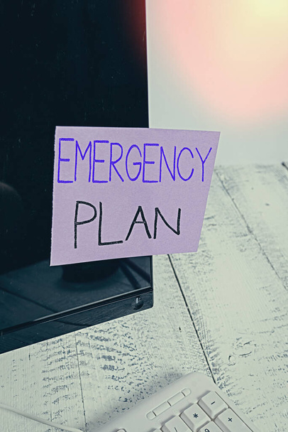 Text sign showing Emergency Plan. Conceptual photo procedures for handling sudden or unexpected situations Notation paper taped to black computer monitor screen near white keyboard. - Photo, Image