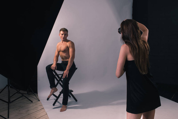 A girl photographs a man in a photo Studio. - Foto, afbeelding