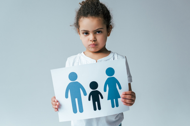 niño afroamericano serio sosteniendo papel con la familia dibujada aislada en gris, concepto de adopción
  - Foto, Imagen