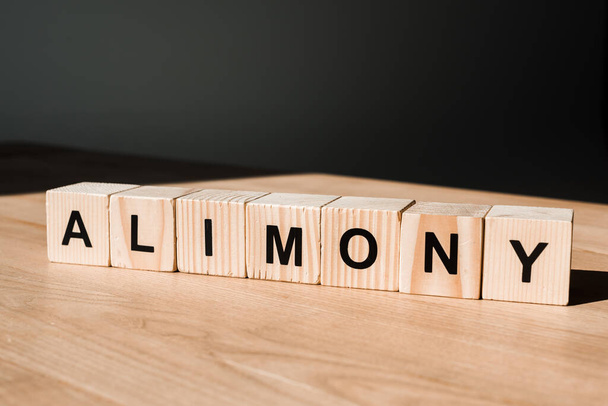 wooden blocks with alimony lettering on black - Photo, image