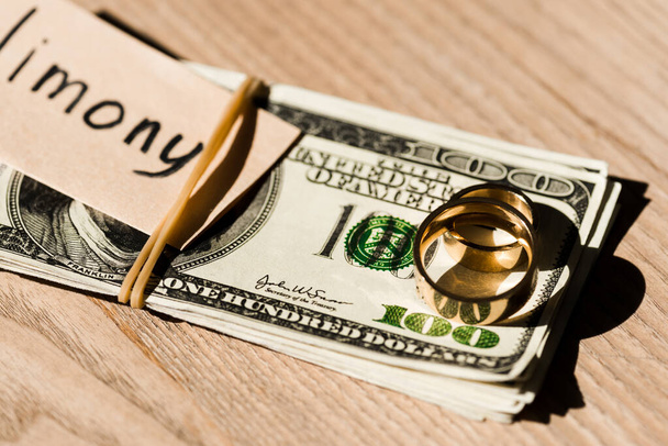 selective focus of paper with lettering on dollar banknotes near engagement rings  - Photo, Image