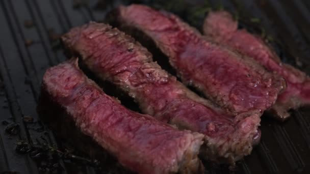Tranches sanglantes steak de bœuf sur une poêle à griller avec de la fumée. Gros plan cuisson de la viande à la maison
 - Séquence, vidéo