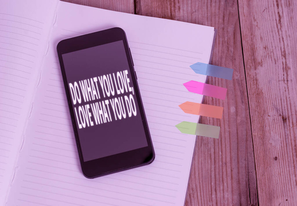 Writing note showing Do What You Love Love What You Do. Business photo showcasing pursue your dreams or passions in life Striped note book colored arrow banners smartphone wooden background. - Photo, Image
