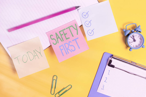 Text sign showing Safety First. Conceptual photo used to say that the most important thing is to be safe Flat lay above table with blank papers with copy space for text messages. - Photo, Image