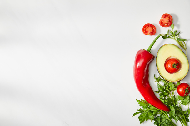 Top view of parsley, chili pepper, cherry tomatoes and avocado half on white background - Photo, Image