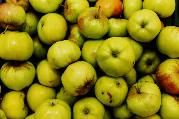 Juicy green apples on a store counter. Vegetarianism and raw food diet. Close-up. View from above.  - Photo, Image