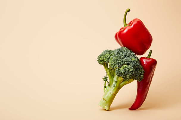 rijpe broccoli, paprika 's van belletjes en chili op beige  - Foto, afbeelding