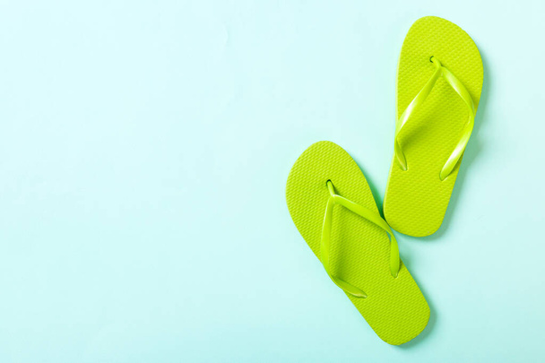 green flip flops on blue background. Top view with copy space. - Photo, Image