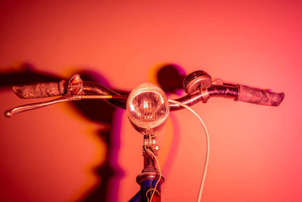 色の色合いと古い自転車からヘッドライトとハンドルバー。ヴィンテージのコンセプト。ネオンライト. - 写真・画像