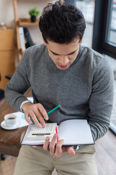 Podnikatel s tužkou a notebookem pomocí kalkulačky v kanceláři - Fotografie, Obrázek