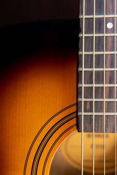 Sound hole of an acoustic guitar, neck, strings, frets, the nut. - Фото, зображення