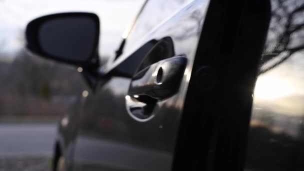 Close-up auto deurkruk, vrouw is het openen van zwarte auto deur en uitstappen auto op straat - Video