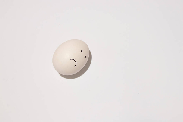 en un huevo blanco, los ojos y la boca se dibujan con un rotulador negro sobre un fondo aislado
 - Foto, imagen