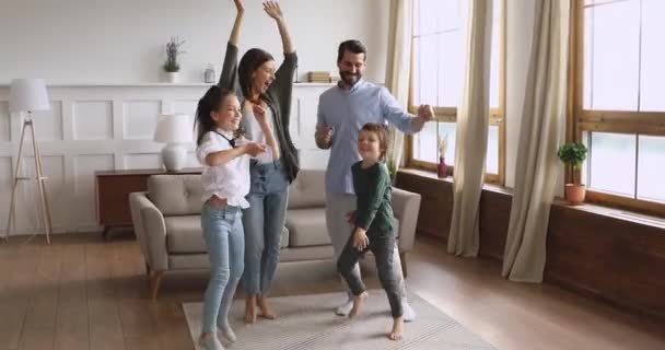 Overjoyed young couple dancing with happy small children. - Metraje, vídeo