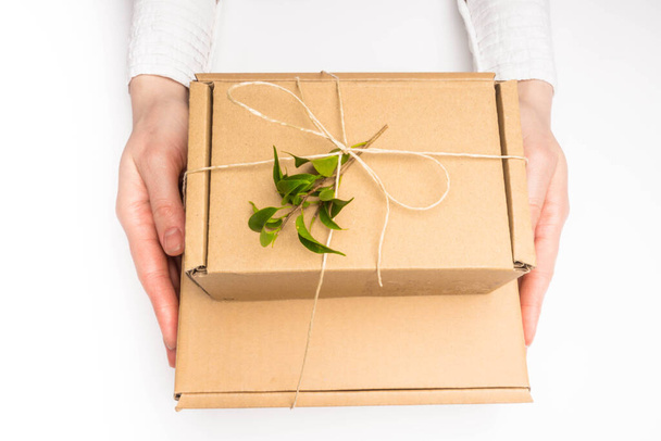 Les mains d'une femme tenant une boîte cadeau zéro déchet en papier artisanal. Cadeaux de Noël et Nouvel An. Concept de vacances saisonnières. Fait à la main
. - Photo, image