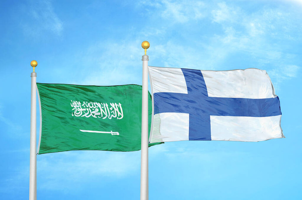 Saudi Arabien und Finnland zwei Flaggen auf Fahnenmasten und blauer bewölkter Himmel Hintergrund - Foto, Bild