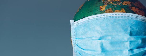 Earth globe with face mask protection. Universal coronavirus medical concept - Photo, Image