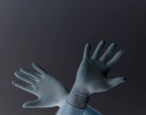 Manos de un hombre protegido del coronavirus. Guantes blancos de látex Proteja su palma de infecciones, virus, gérmenes. Aislamiento de la piel Símbolo de protección contra el peligro de infección. La obstrucción, una barrera a la enfermedad
. - Foto, Imagen