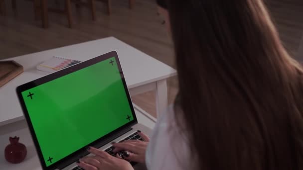 Ev soyutlanmış. Evde oturan kadın, Yeşil Model ekranlı bir dizüstü bilgisayarın üzerinde çalışıyor. Coronavirus Covid-19 uzaktan eğitim ya da çalışma konsepti karantinası. Bilgisayar Kullanan Kız, Tarayıcı - Video, Çekim