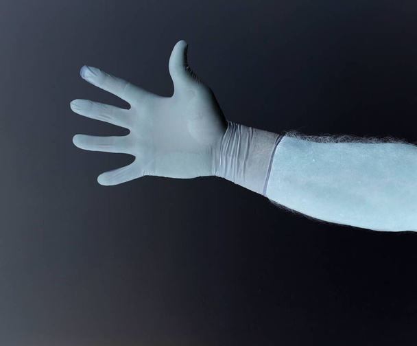 Manos de un hombre protegido del coronavirus. Guantes blancos de látex Proteja su palma de infecciones, virus, gérmenes. Aislamiento de la piel Símbolo de protección contra el peligro de infección. La obstrucción, una barrera a la enfermedad
. - Foto, Imagen