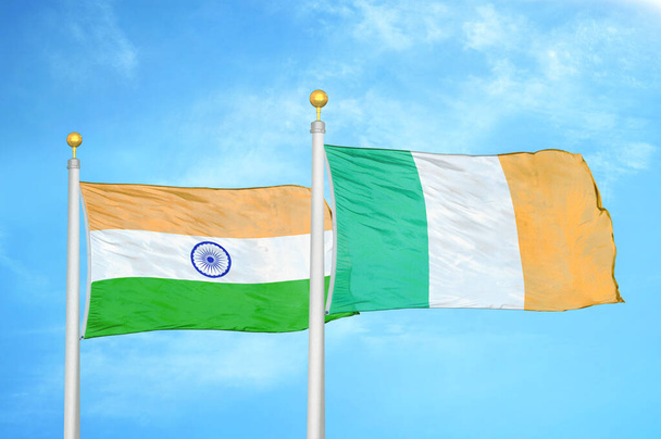 Ινδία και Ιρλανδία δύο σημαίες σε κοντάρια σημαίας και μπλε θολό φόντο του ουρανού - Φωτογραφία, εικόνα