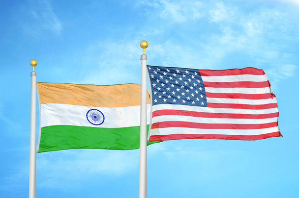 India y Estados Unidos dos banderas sobre asta de bandera y fondo azul cielo nublado
 - Foto, imagen